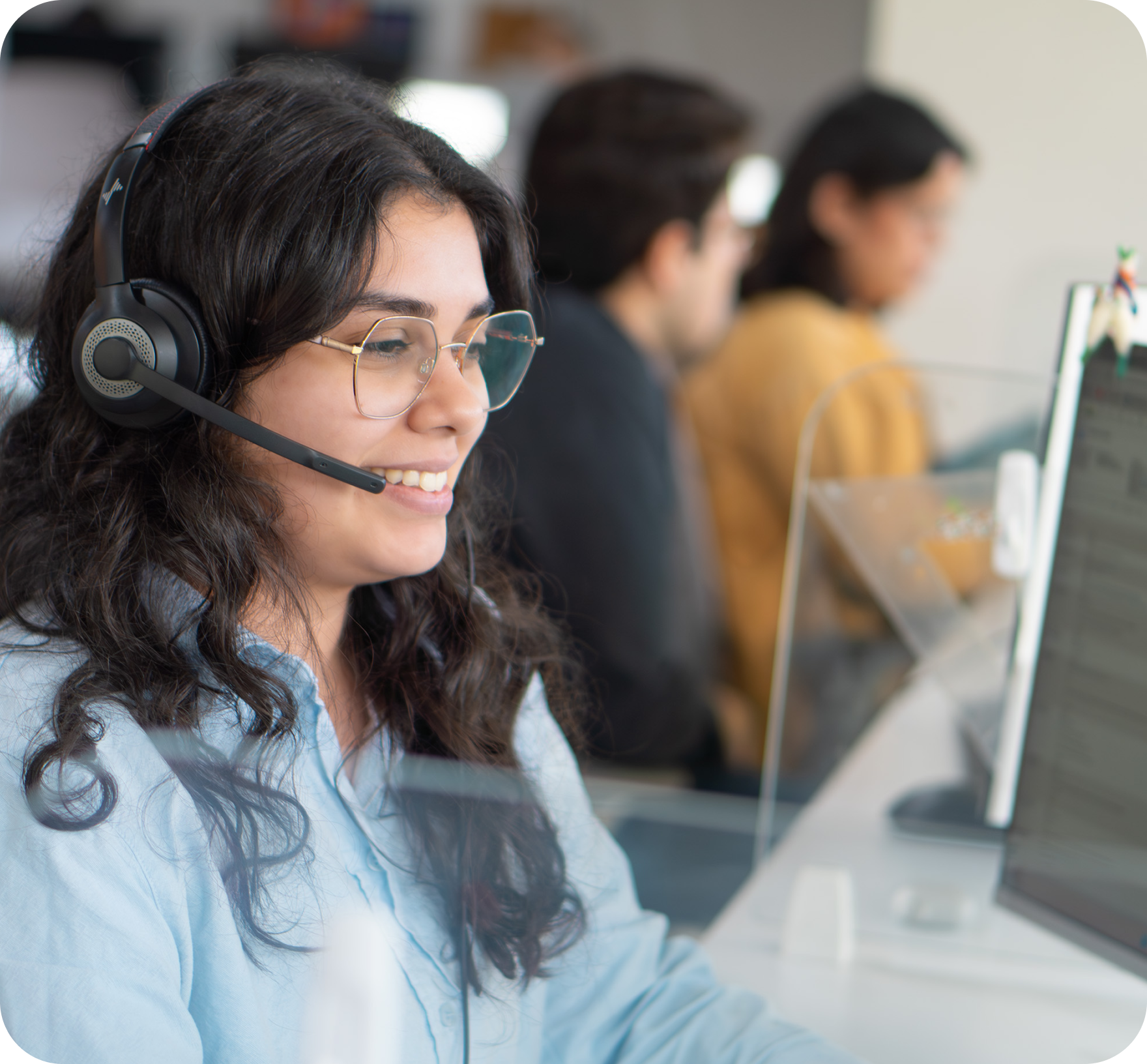 A Work Ninjas lead coordinator on a headset call, mid-conversation with a call-center bullpen behind her
